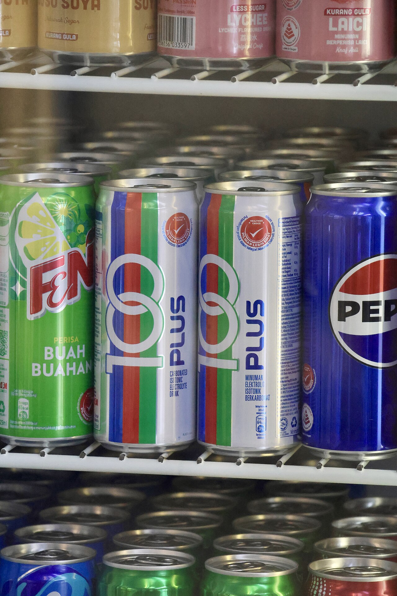 Cans of 100PLUS on a shop shelf beside other soft drinks