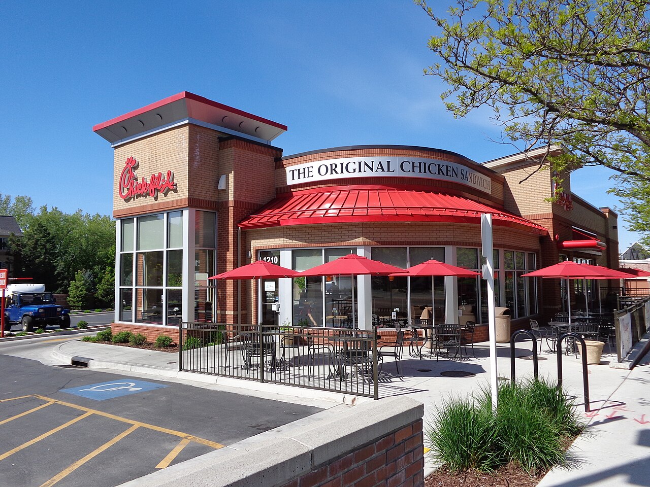 A Chick-fil-A restaurant with red awnings and outdoor seating