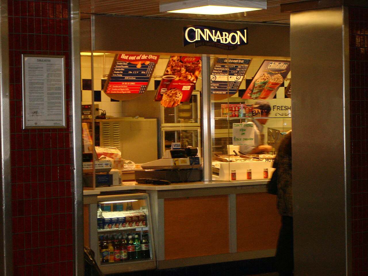 A Cinnabon counter with baking trays visible behind the glass