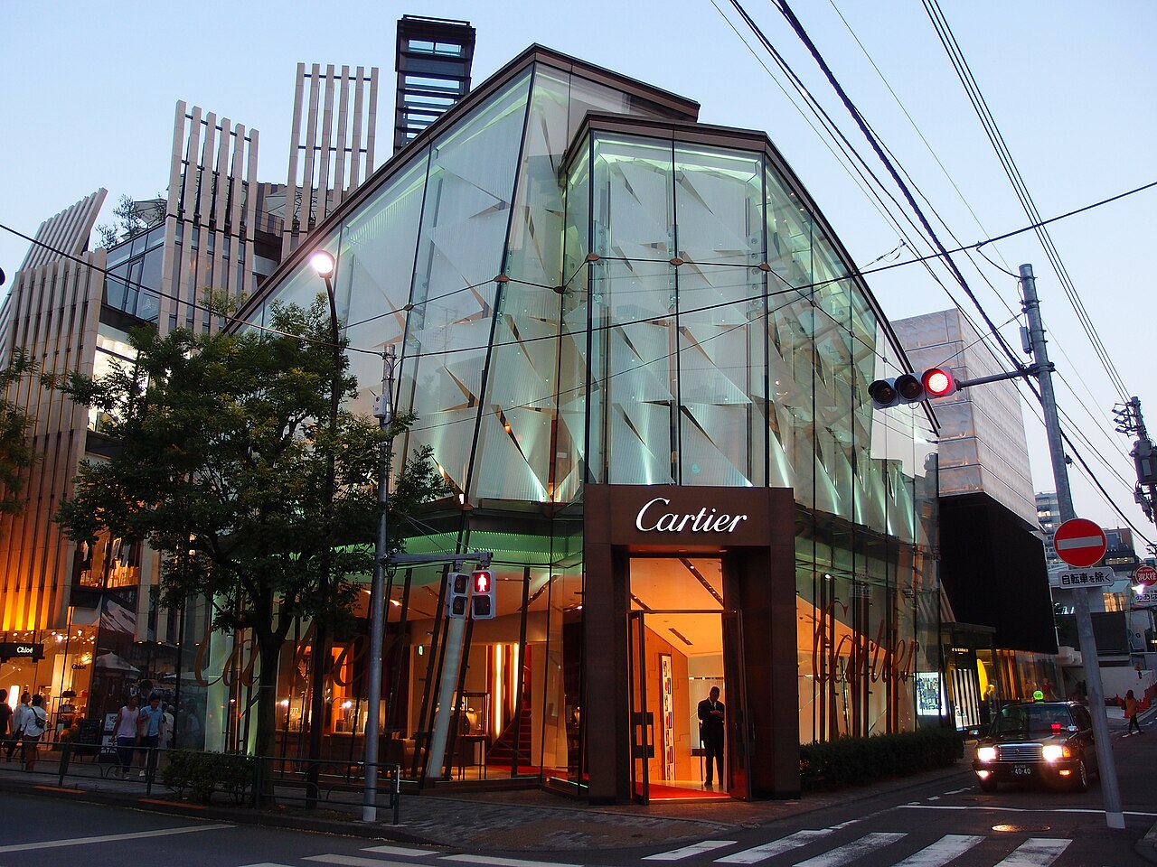 Glass-fronted Cartier boutique in Aoyama, Tokyo, photographed at dusk.