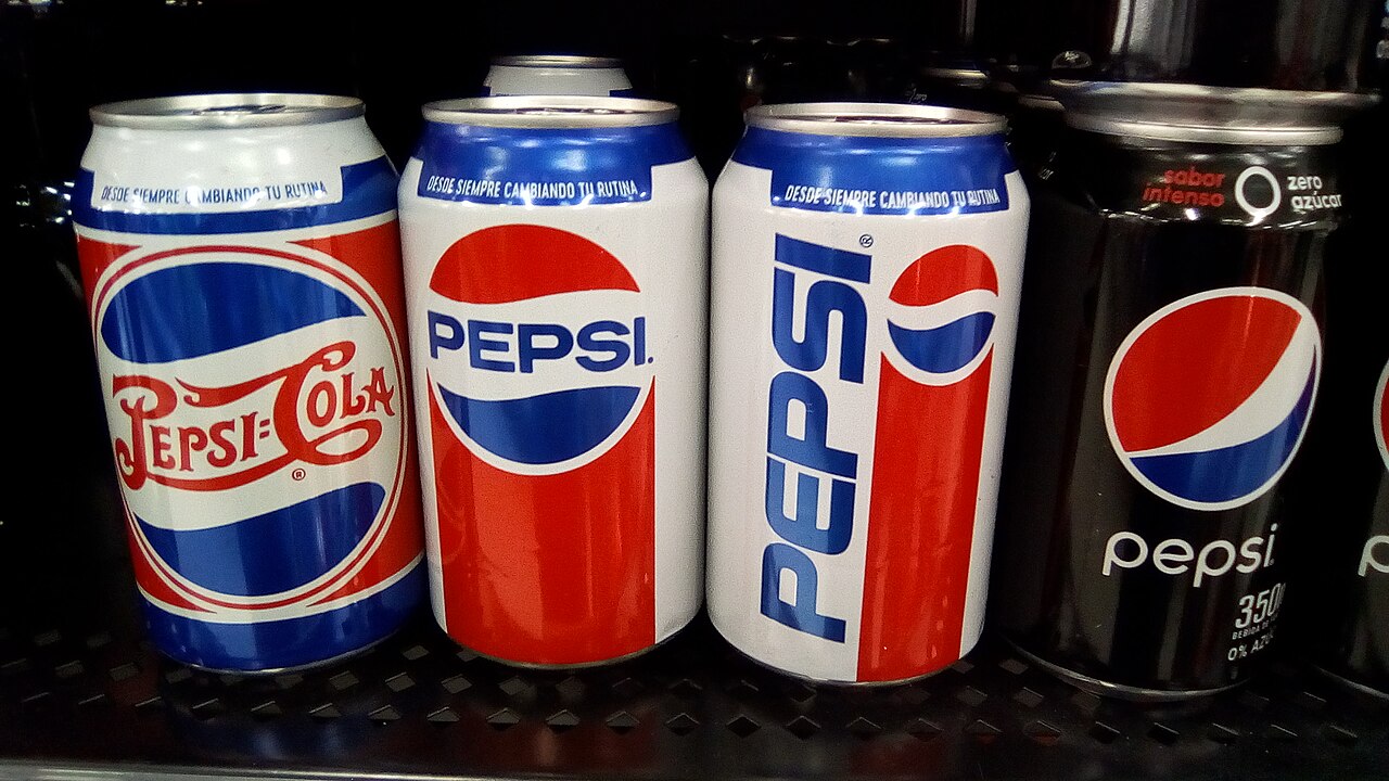 Pepsi cans showing several logo designs over the years