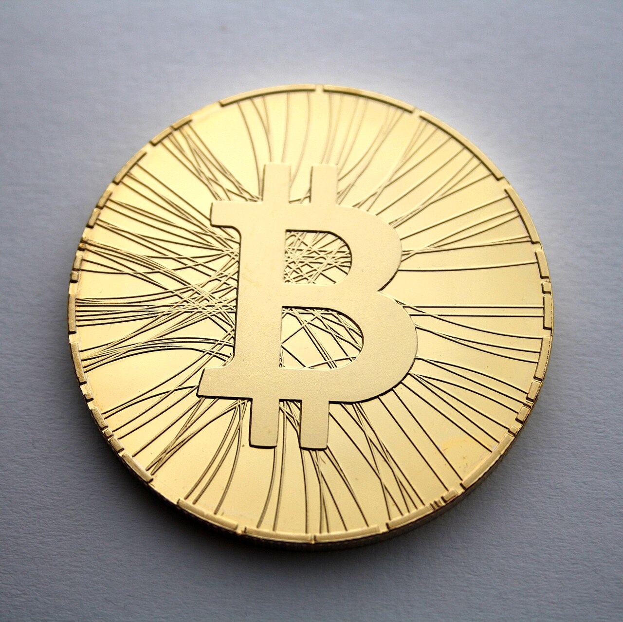 A gold-coloured novelty coin stamped with the Bitcoin B symbol