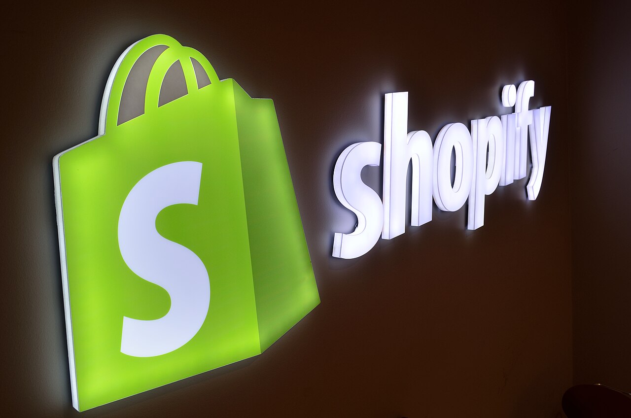 Illuminated Shopify shopping-bag logo and lettering on a wall at the Shopify office in Toronto